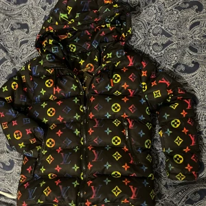 Louise Vuitton Vinterjacka  - Klä ditt barn i en riktigt häftig Barn vinterjacka från Louise Vuitton. Storlek 5-6 år I använt gott skick,  väl omhändertagen 