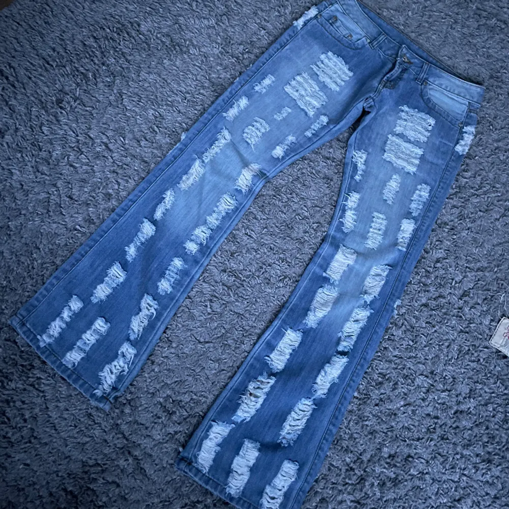 Lågmidjade bootcut jeans med hål Midjemåttet 40  Innerbenslängd 83  Ytterbenslängd 102. Jeans & Byxor.
