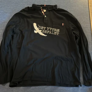 46. Svart det yttre befälet Långarmad tröja  - Det yttre befälet Merch gjord av bandet själva. Svart långärmad tröja i bra skick. Det står ingen storlek men den uppskattas vara runt XXL