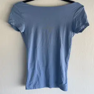 Blå backless t-shirt/ Topp i storlek xs. Passformen är tight. Den är i bra skick nästan ny skick då jag endast använd den max 2-3 gånger. (Obs, ”fläcken” på framsidan av tröjan är pga ljuset) 