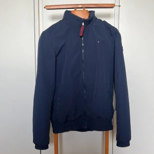 Tommy Hilfiger jacka - Vindjacka, vårjacka, junior stl 176. Trasig ficka. I övrigt mycket bra skick. 