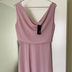 Säljer denna nya rosa klänning, den är aldrig använd och har prislappen kvar. Klänningen är i passform ”tall” och i storlek 36. Den passar lika bra till bröllop såsom till en bal. På baksidan har den fina knappar.