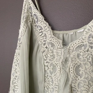 Grönt linne - Gulligt, pastellgrönt linne med så fina spetsdetaljer. Använt sparsamt. 