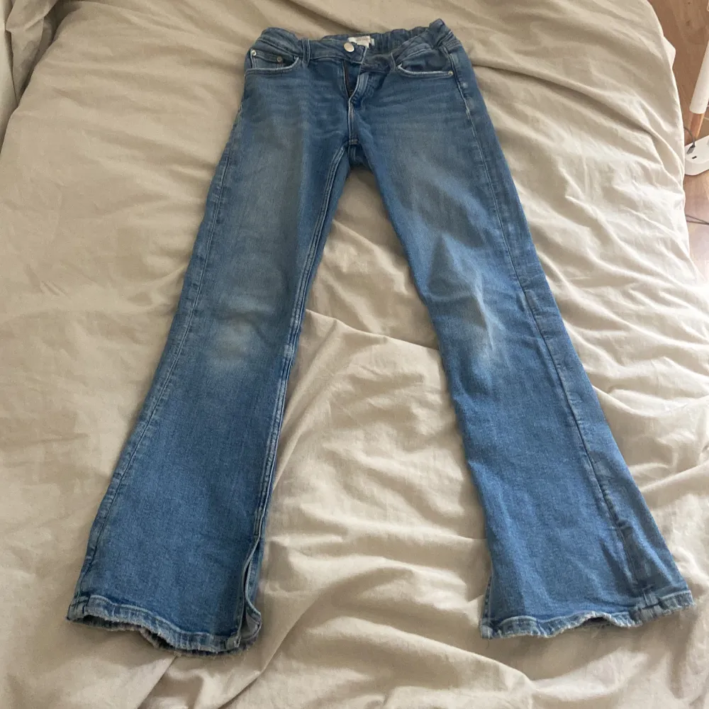 Blåa jeans från Gina Tricot. Köpta för cirka ett år sedan. Utsvängda med en snitt på innersidan. Säljer för att de inte passar så bra på mig. Är 160 Tvärs över midjan: 29cm. Lite slitna vid fötterna och midjan. Fråga om mer bilder eller detaljer!. Jeans & Byxor.