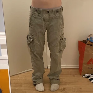Gröna cargo/arme byxor - Jätte fina ljusgröna cargo byxor från Alpha Industries! Står ingen storlek så gissar på typ S/M. Midjemått: 40cm rakt över, Innerbenslängd: 82cm men kan vikas upp som jag gjort vid behov!! Skulle säga att dessa passar som både low, mid o high waist!❤️