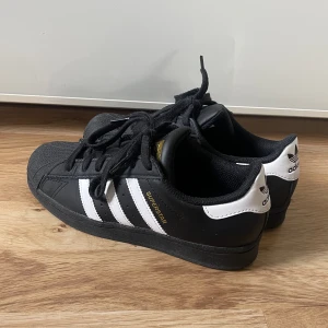 svarta adidas superstar - säljer mina svarta adidas superstar i storlek 36 2/3, använda två gånger! 