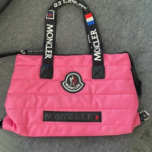 Moncler väska - Hej, säljer en super snygg   F.  A.  K.  E.  Rosa Väska köpt i Turkiet, ser äkta ut o är i mycket bra skick. Får plats med dator och allt.