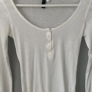 långärmad vit tröja med knappar från H&M🙏 - den är lite genomskinlig och det får den att se ut som en intimissi tröja, storlek 36 💕
