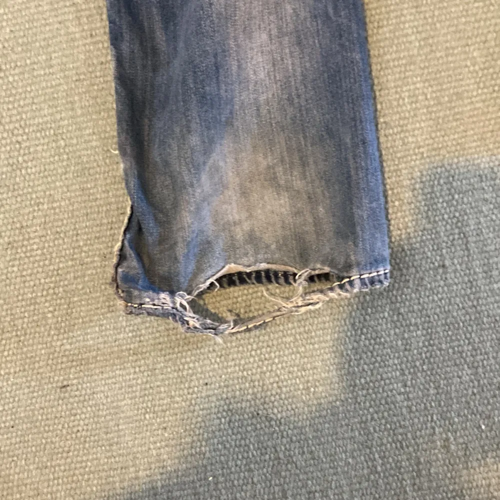 Säljer ett par True religion jeans bra skick förutom ett litet hål längst ner på byxorna, ganska baggy storlek 36. . Jeans & Byxor.