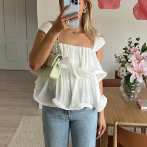 Lojsan Wallin x NAKD - frills topp - Vit söt topp i storlek 34. Säljer då den tyvärr var för liten. Självklart helt ny och med alla lappar kvar! Då den är slutsåld så säljer jag den här för att ge någon annan chansen att få tag i den. Säljer för samma pris som på hemsidan. 499kr🌸