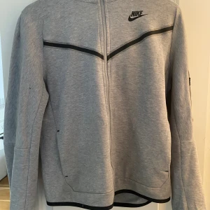Nike tech fleece - Nike tech säljes på grund av lite användning. Storleken är 164-170 men passar ca XS. Varan är använd fåtal gånger men har en liten fläck på armen som inte syns på(finns på sista bilden)