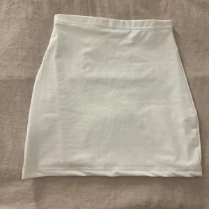 Vit kort kjol - Säljer den här oanvända vita kjolen, säljer även en likadan i svart, om någon är intresserad! 