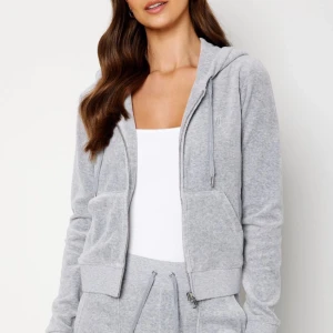 Grå Juicy Couture kofta - Säljer nu min gråa Juicy kofta, använd 1 eller två gånger så den är i nyskick! Kan skicka egna Bilder om så önskas. Storlek S. Säljer även ett par byxor i xs som är lite smått slitna längst nere i benen men annars också i fint skick!💞💞