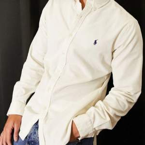 Super fin vit skjorta i bra skick med marinblå logg på bröstet.
