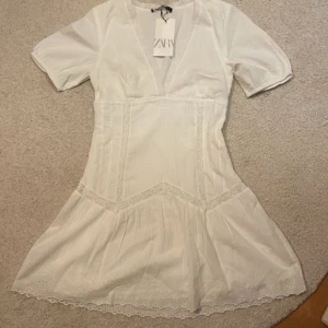 Vit klänning - Populär klänning från zara i st S! Aldrig använd med lappen kvar, dragkedjan på sidan går inte att dra ner men går lätt att trä över klänningen!⚡️🌸