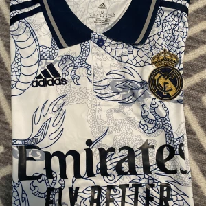 Real Madrid Jersey storlek M - Real Madrid Jersey. Med vini jr, där back. Perfekt nu inför sommaren. Skriv om ni har funderingar. Tar gärna extra bilder