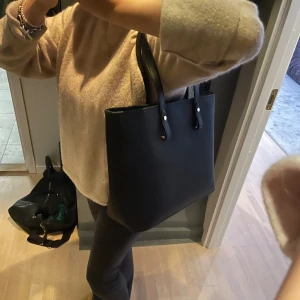 Handväska - En svart handväska från H&M. Nästan helt oanvänd och väldigt rymlig. Perfekt som skolväska. Pris kan diskuteras.