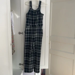 Rutig jumpsuit - Använder den inte längre. Har fickor. Katter i hemmet. Blixtlås på sidan