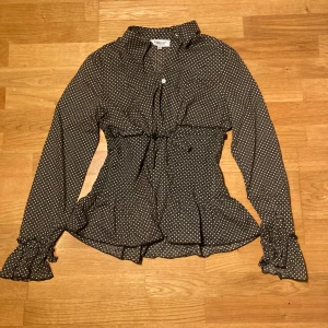 prickig blus med volanger - jätte söta detaljer, rosett i midjan, elastisk i midjan så drn sitter räfflat, färgen är lite brungrön, välldigt bra skick