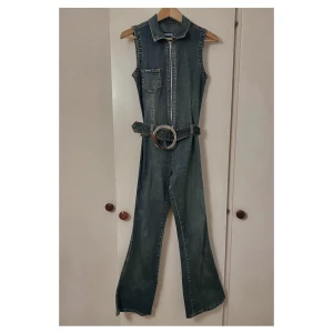 Retro byxdress i denim - Supersnygg vintage byxdress i jeans, ganska stretchigt tyg. Bälte med stort spänne som sitter lågt i midjan. 