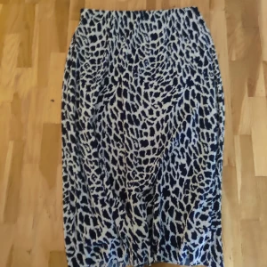 Mönstrad kjol från Kiomi - Midikjol i mycket fint skick. Blå och vit. Storlek 40. Resår i midjan.