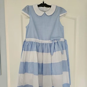 Blå och vit klänning - Så fin blå och vit klänning med midjeband som knyts i ryggen. Nyskick!!