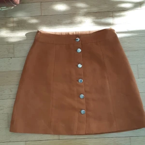 Kjol  - Kjol i mockaliknande tyg.   Säljer min favoritkjol som jag nu har växt ur.   Köparen står för frakt