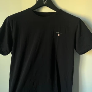 Gant T-shirt - Tja, säljer en svart gant t-shirt då den är för liten och inte används. Endast använd ett fåtal gånger ( nyskick). Tveka inte att skriva vid eventuella funderingar 