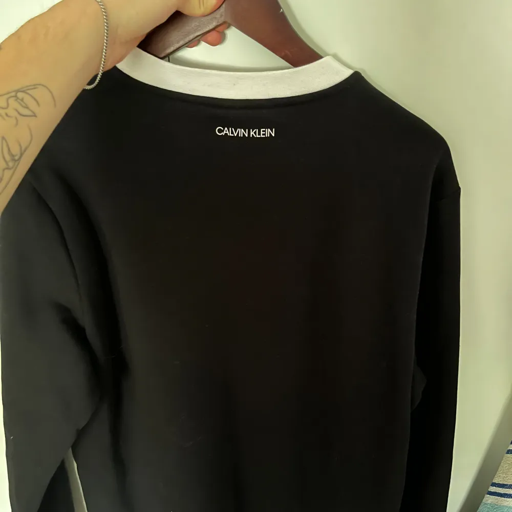 Calvin Klein sweatshirt i färgen svart och storlek L. Använd ett få tal gånger över förra sommaren. Fint skick på plagg och färg. Tröjor & Koftor.