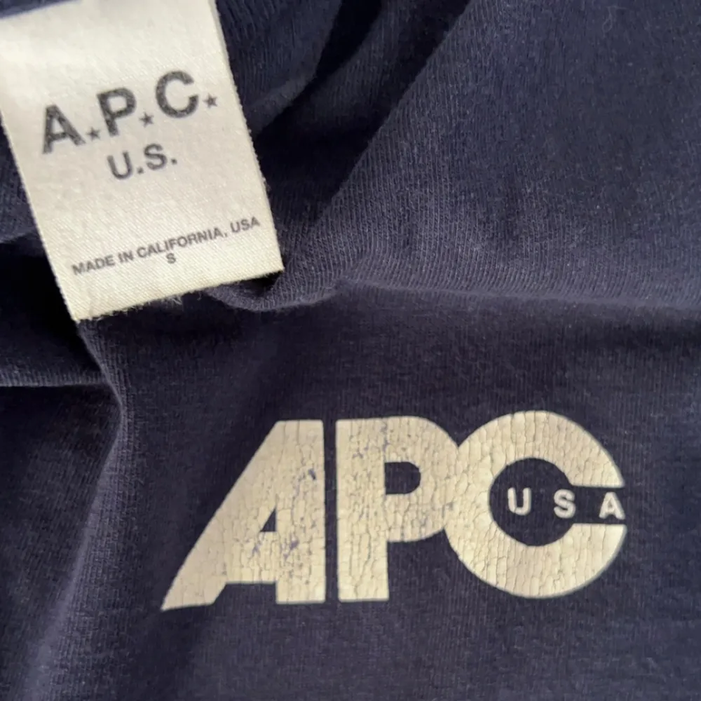 Mörkblå APC tshirt i riktigt bra skick. Inga defekter! (Sprickorna på texten är del av designen). Nypris runt 1200kr.. T-shirts.