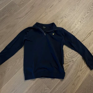Lyle & Scott half zip - En fräsch marinblå Lyle & Scott halfzip i bra skick och i storleken 14-15 år, men passar även S och XS.