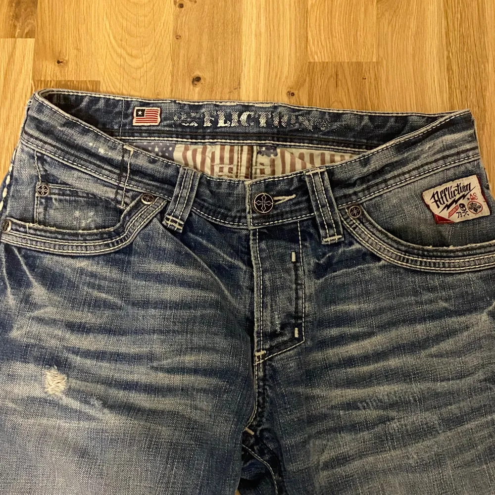 Affliction jeans i bra skick, säljer för behöver pengar. Sjukt snygga detaljer, storlek L/Xl?. Midjemått: 88cm innerbensmått: 87,5cm Benöppning: 22cm. Jag är 157cm men dom är för långa. Ända defekt är slitningen längst ned vid benet.. Jeans & Byxor.