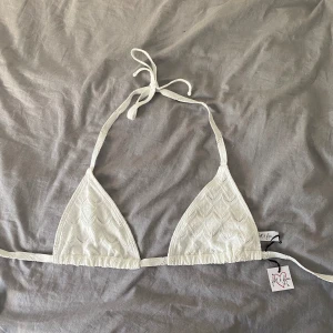 Vit bikini överdel  - Helt ny vit bikini överdel med broderi som är köpt på Vinted men passade inte mig så säljer därför vidare. Aldrig använd av tidigare ägare och aldrig av mig, prislapp fortfarande kvar. Nypriset skulle vara 175kr. 