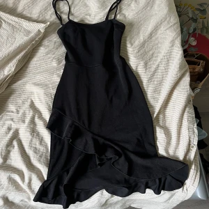 Svart miniklänning  - Använd 2 gånger, från nelly 2020 ungefär! Superfin baktill då man knyter den med rosett. Tight klänning med volanger nedtill.