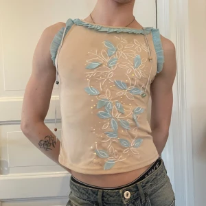 Beige ljusblå volang linne pärlor paljett sidenband broderat - Vintage beiget linne med volanger längst ärmar och hals, broderat, paljett tyget och 3D detaljer på framsidan och hängande satinband med pärlor längst ner 🪐🪐