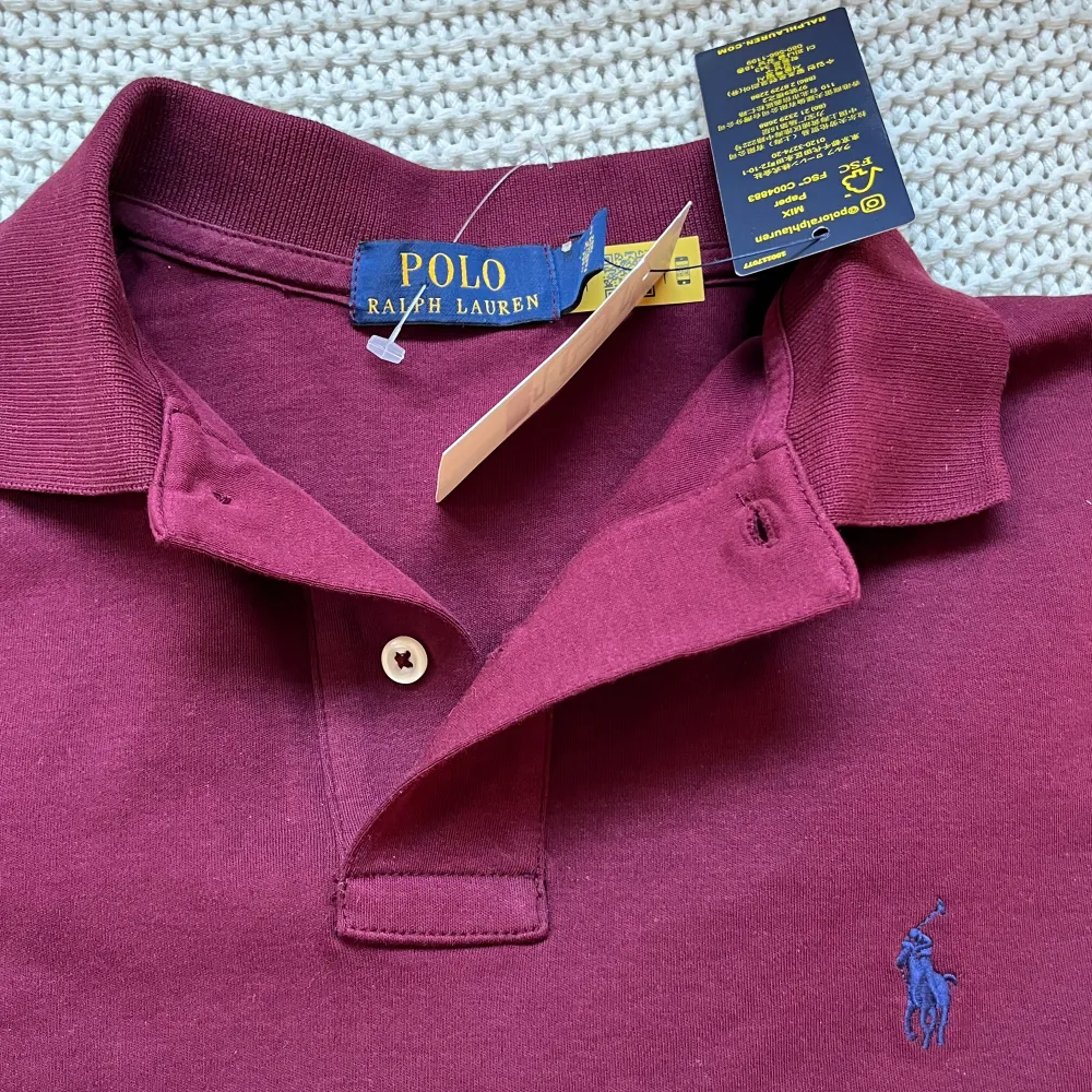 Ralph lauren pike i en vinröd/burgundy färg. Helt oanvänd med tagsen kvar. Storlek S.. T-shirts.