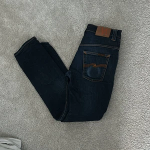 Nudie Jeans - Säljer min nudie jeans då de ör försmå för mig. Storlek 30/32 och sitter slimfit vilket är riktigt fett. Skick 7/10 då de har fått lite missfärgning på bakfickan och ena framfickan men är en riktig snygg detalj.  Pris kan diskuteras 
