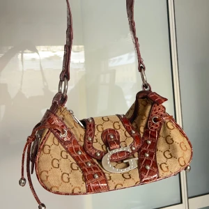 Väska  - Super fin handväska, i toppskick utan defekter. Sluts med dragkedja. Har två fack på insidan varav ett har dragkedja. Vill du köpa trycker du på köp nu, jag postar inom 24h