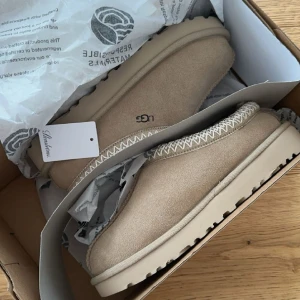 Ugg tasman - Säljer mina aldrig använda uggs modellen tasman i färgen mustard seed/white. Lappen till de tog jag av men kommer art skickas i orginalbox. Något mindre i storleken, har vanligtvis 36,5/36 och de passar mig perfekt. Egenbild^^ Slutsålda överallt.🤍