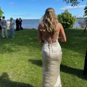 Klänning - Jättefin champagnefärgad klänning perfekt till bal. Endast använd en kväll, har liten reva, kan skicka bild privat. Köparen står för frakten. Nypris 999kr.