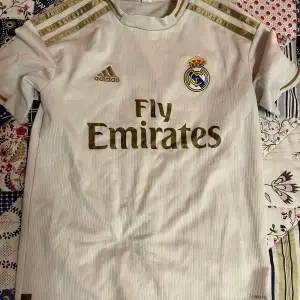 Hej jag säljer än real Madrid tishirt i Skick 8/10 den är använd ett få par gånger under sommaren storlek 140 