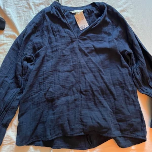 Marinblå blus - Säljer denna härliga marinblå blusen från H&M, aldrig använd och i nyskick. Nypris är 279kr och jag säljer för 145kr