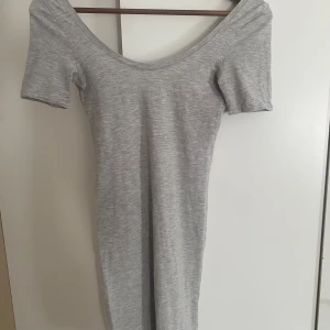Grå klänning - Otrolig snygg klännign. Typ body con klänning men den är kort och lite grnomskinlig men funkar perfekt med hudfärgade undrr kläder. Ärmarna är uppsydda lite men ingen som synd när den är på. Den kommer lite över knärna på mig som är 168