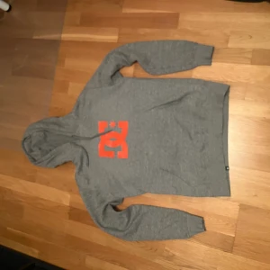 Grå Dc hoodie - Jag köpte tröjan på sellpy men den var för stor. Jag har själv inte använt den och den har inga hål eller tecken på slitage. Mått finns på sista bilden. Skriv till mig om ni har frågor om mått eller annat. 