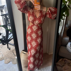 Lång klänning med mönster  - Säljer min aldrig använda långklänning då jag inte får användning för den!  Super snyggt med öppen rygg och även en dragkedja vid svanken. 