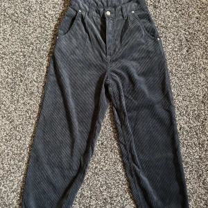 Svarta jeans - Osäker på vad den här stilen av jeans heter men dom har typ ett randigt material, botten av byxorna är vikta/ cuffed