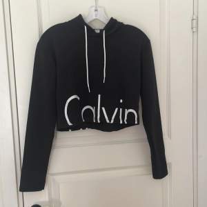 Supersöt Calvin Klein croppad hoodie, använd några gånger. Färgen på märken har flagnat lite men inget som syns mycket. Strl S.