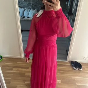 Rosa balklänning  - Superfin knallrosa klänning, aldrig använt, etiketten är kvar. Väldigt luftig och bekväm, sitter som en smäck på kroppen och det går att anpassa hur tajt man vill att den ska vara vid midjan. Nypris 699:-, säljer för 500kr Skriv vid övriga frågor😇