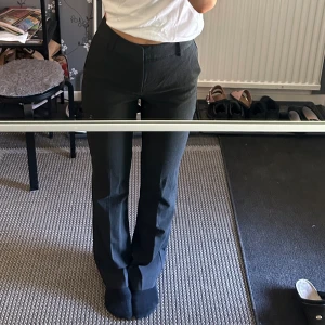 Mörkgrå kostymbyxor  - Mörkgråa kostymbyxor med högmidja. Från Bibok. Aldrig använda och prislappen kvar.