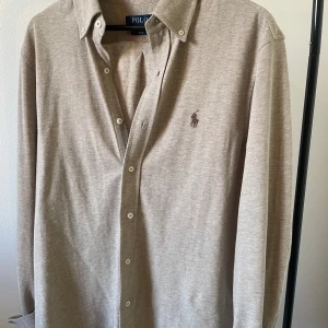 Polo Ralph Lauren skjorta - Tja, säljer nu den här tvär feta skjortan i färgen beige. Helt ny och oanvänd så därför 10/10 skick. Kvitto finns. Hör av er vid frågor! 